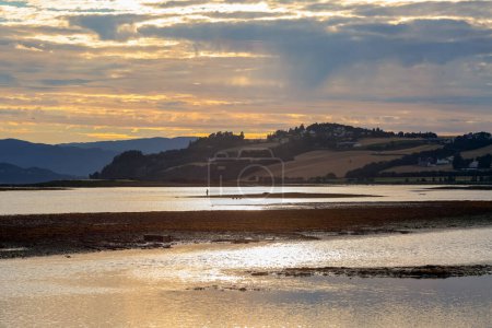 River Gaula, Trondheim fjord, agricultural area Byneset, Gaulosen nature reserve and fishing man during low tide and colorful august sunset 