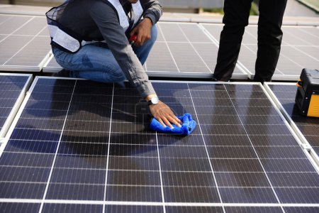 Solartechniker beim Reinigen des Solarmoduls, Konzept für grüne und erneuerbare Energien