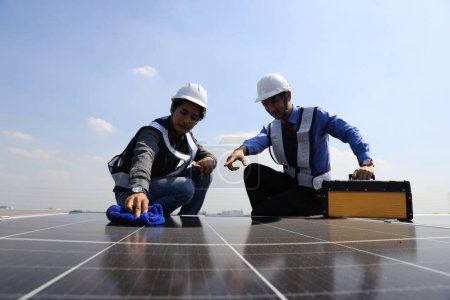 Téléchargez les photos : Solar technician cleaning the solar panel , Green and renewable energy concept - en image libre de droit