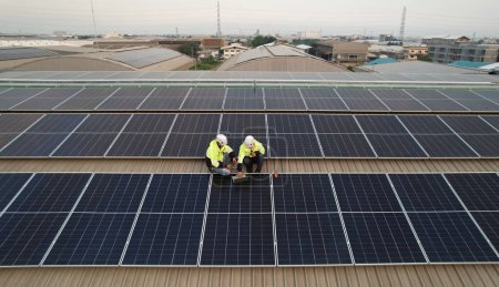 Foto de Instalación de techo solar, Ingeniero con EPI de seguridad y arnés instalar células solares en el techo de la fábrica, energía renovable verde - Imagen libre de derechos