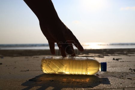 Equipo profesional y voluntario vistiendo PPE limpiar sucio de derrame de petróleo en la playa, mancha de aceite lavada en una playa de arena