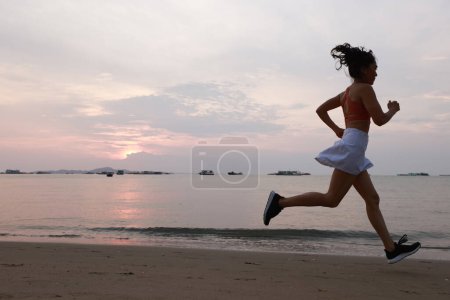 Foto de Increíble mujer sana y alegre saltar entre el cocotero en la playa - Imagen libre de derechos