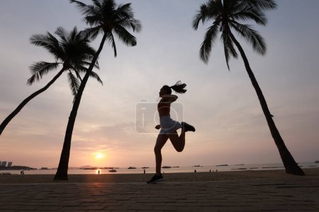 Téléchargez les photos : Femme incroyable saine et joyeuse sauter parmi le cocotier sur la plage - en image libre de droit