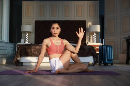 Téléchargez les photos : Jeune femme asiatique faisant de l'exercice de yoga à la maison le matin, concept de mode de vie sain. - en image libre de droit