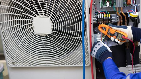 Foto de Close up Air conditioner's technician hand check  electrical circuit and maintenance condensor unit, Home care service - Imagen libre de derechos