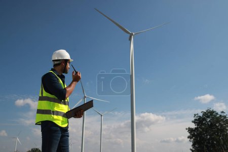 Blue collar worker at electricity site. Windmill farm