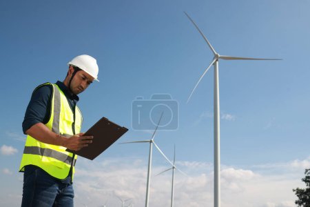 Photo for Blue collar worker at electricity site. Windmill farm - Royalty Free Image