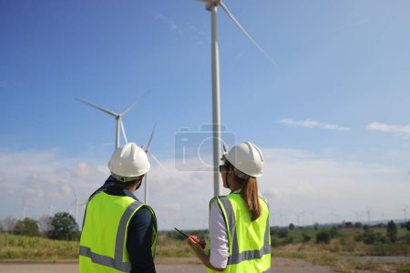 Foto de Un par de ingenieros eléctricos trabajando juntos en una granja de aerogeneradores. - Imagen libre de derechos