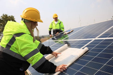 Die zukünftige elektrische Produktion. Männliche und weibliche Kollegen lesen Zeichnungen von Sonnenkollektoren, grüner Energie und erneuerbaren Energiekonzepten