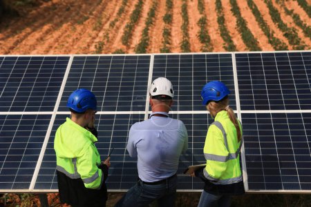 Téléchargez les photos : Ingénieur en chef avec équipe d'ingénieurs discutant au panneau solaire, concept d'énergie durable - en image libre de droit