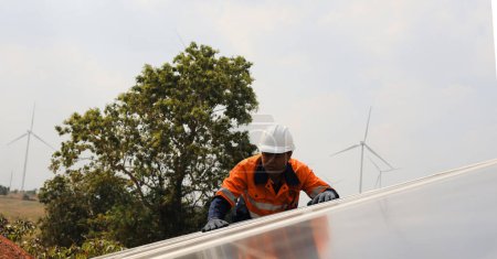 young woman engineer in helmet working with wind turbine at construction site
