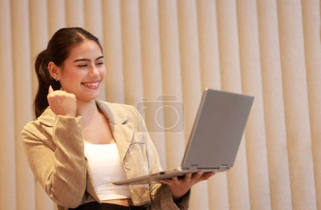 Alegre mujer de negocios comprobar la información de la computadora portátil y entregar animar el éxito