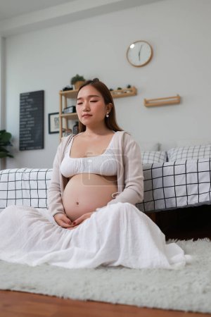 Foto de Mujer embarazada meditando, Mujer embarazada practicando técnicas de meditación mindfulness - Imagen libre de derechos