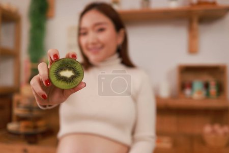 Téléchargez les photos : Femme enceinte préparant des aliments sains avec beaucoup de fruits et légumes à la maison - en image libre de droit