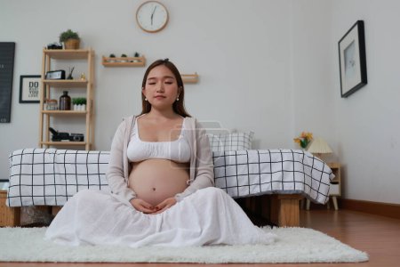 Téléchargez les photos : Femme enceinte méditant, Femme enceinte pratiquant des techniques de méditation pleine conscience - en image libre de droit