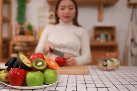 Photo for Pregnant woman preparing healthy food with lots of fruit and vegetables at home - Royalty Free Image