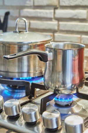 Kochen in Pfanne und Topf auf Gasherd in der Küche. Konzept der Hausmannskost.