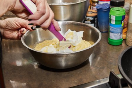 Chef en la cocina casera mezcla puré de papas con crema agria.