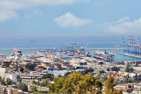 Foto de Haifa, Israel - 17 de junio de 2023: Puerto marítimo en la ciudad de Haifa, panorama del puerto y un barco parado en la carretera contra un cielo azul con nubes. - Imagen libre de derechos