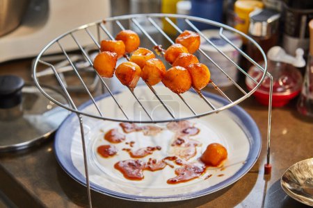 Téléchargez les photos : Boules de melon, coupées avec une cuillère spéciale, frites au caramel. - en image libre de droit