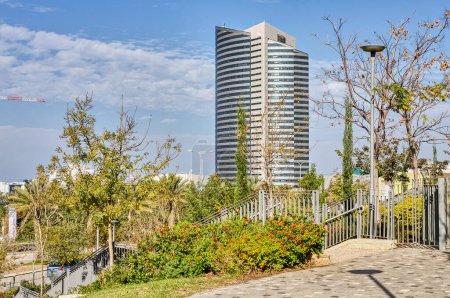 Téléchargez les photos : Vue panoramique d'un bâtiment d'une compagnie d'électricité à Haïfa, Israël, situé au milieu d'herbe verte luxuriante et d'arbres. - en image libre de droit