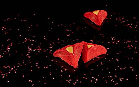 Téléchargez les photos : Oreilles Hamans - hamantash sont rouges, avec le goût de velours rouge sur un fond noir avec réflexion. - en image libre de droit