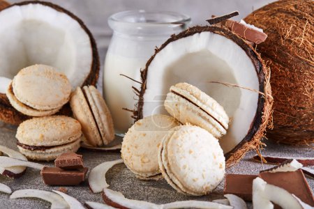 Kokos-Macarons mit Schokolade und Kokosflocken auf einem Tisch mit einer Kokosnuss im Hintergrund. Das perfekte Image für einen Food-Blog oder eine Rezept-Website.