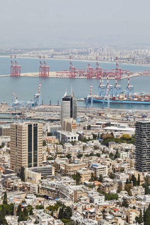 Foto de Haifa, Israel - 20 de abril de 2024: Puerto marítimo en la ciudad de Haifa, panorama del puerto y los edificios de la ciudad sobre el fondo de un cielo azul con nubes. - Imagen libre de derechos