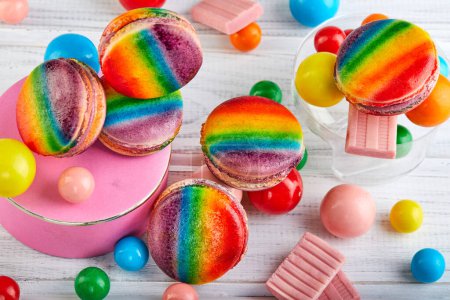 The table is filled with a variety of candies and gums, showcasing a variety of rainbow macaron flavors and textures to satisfy any sweet tooth.