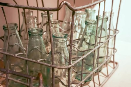 Vintage milk glass bottle in metal wire box of Soviet times corner view
