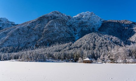 Téléchargez les photos : A sunny winter morning ata snowy and iced Lake Dobbiaco, Province of Bolzano, Trentino Alto Adige, Italy. - en image libre de droit