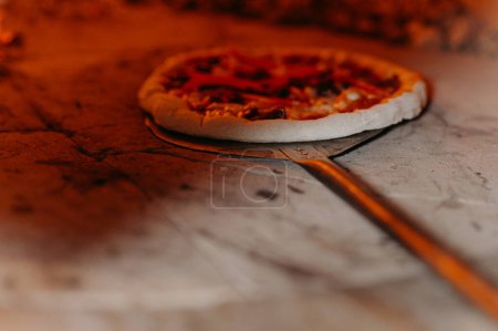 Foto de La pizza italiana se cocina en un horno a leña.. - Imagen libre de derechos