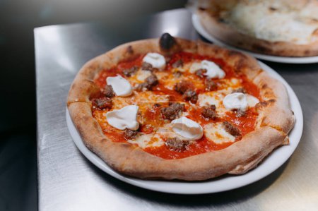 Téléchargez les photos : Pizza à la saucisse et salade de fusée sur table en bois. - en image libre de droit