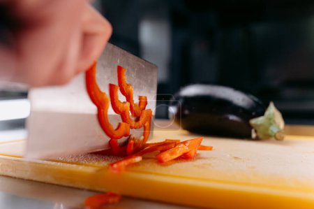 Photo for Cutting fresh red pepper into strips. cutting vegetables - Royalty Free Image