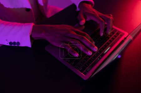 Foto de Male hands typing on the notebook keyboard. african american man working on laptop - Imagen libre de derechos