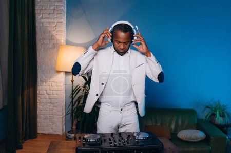 Foto de A DJ in a white suit listens to music, sings and dances. a man listens to music at a party.Neon light. - Imagen libre de derechos