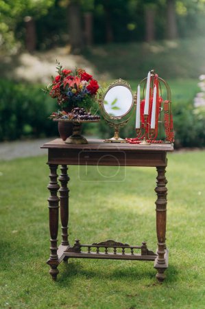 Photo for Wooden table with mirror, candle and flowers. Morning of the bride. - Royalty Free Image
