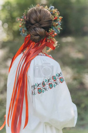 Foto de Una hermosa chica ucraniana con un vestido bordado. Una mujer con una corona de flores en la cabeza. - Imagen libre de derechos