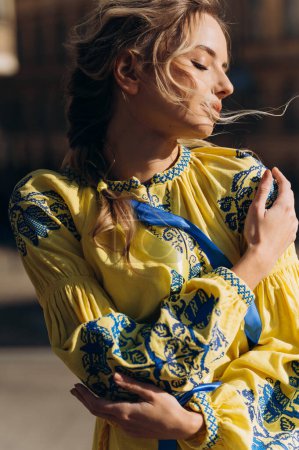 Téléchargez les photos : Une jeune fille en robe brodée ukrainienne au soleil. Robe ukrainienne jaune. - en image libre de droit