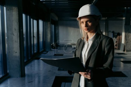 Photo for Portrait of a businesswoman, an engineer at a construction site. Female architect with blueprint. - Royalty Free Image