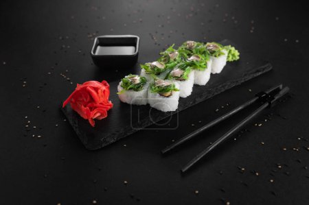 Foto de Sushi con algas verdes. Palitos de comida. La parte superior está soplando. - Imagen libre de derechos