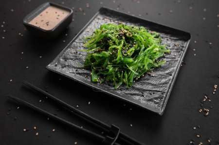 Foto de Ensalada de algas Wakame con semillas de sésamo. Comida tradicional japonesa. - Imagen libre de derechos