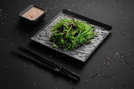 Téléchargez les photos : Salade d'algues Wakame aux graines de sésame. Nourriture japonaise traditionnelle. - en image libre de droit