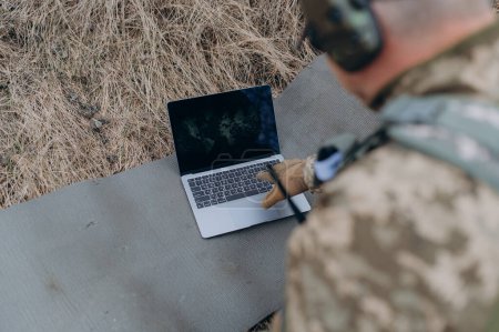 Photo for A soldier works on his laptop. - Royalty Free Image