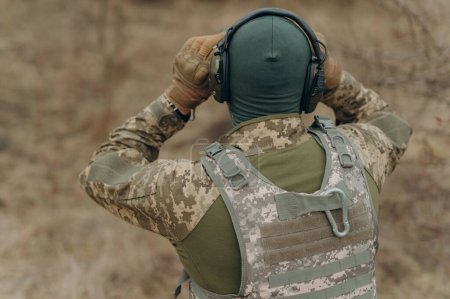 Téléchargez les photos : Un soldat en camouflage tient des jumelles. militaire tenant des jumelles. soldat sur le terrain - en image libre de droit