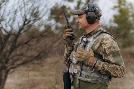 Foto de Un soldado habla en un walkie-talkie. - Imagen libre de derechos