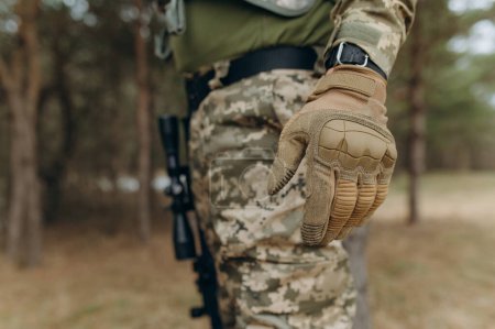 Photo for Military hand. Camouflage tactical gloves. - Royalty Free Image
