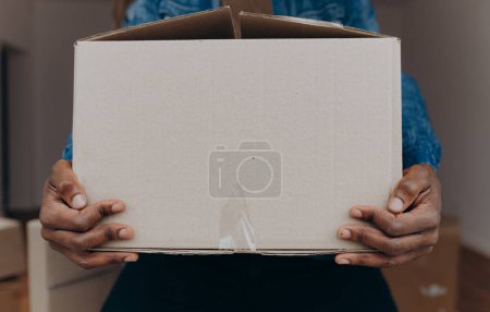 Foto de El hombre levanta una caja de cartón - Imagen libre de derechos