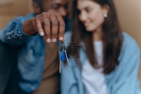 Téléchargez les photos : La main d'un jeune homme noir montre les clés d'un nouvel appartement - en image libre de droit