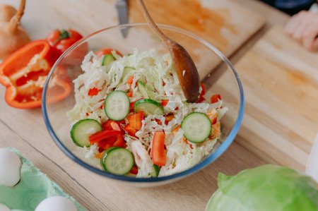 Téléchargez les photos : Gros plan sur une salade de légumes. mélanger les ingrédients de la salade super-alimentaire avec des cuillères - en image libre de droit